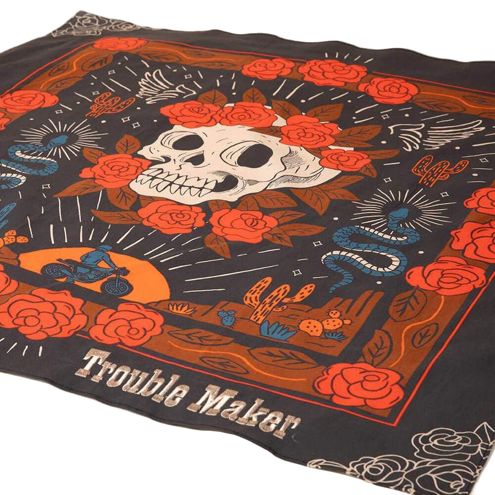 Dog bandana with skull and roses design and 'Trouble Maker' text on a gray background.