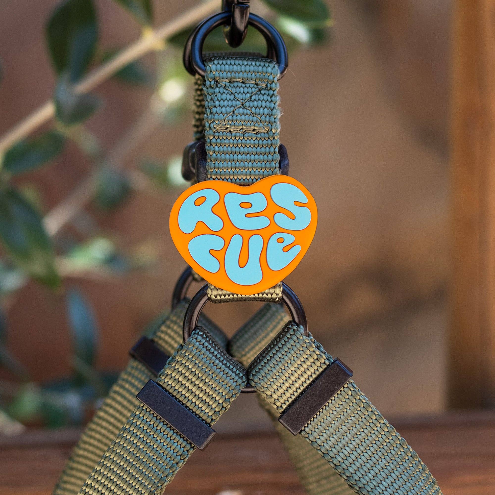 An orange, heart-shaped silicon jiby with "rescue" written on it in blue.