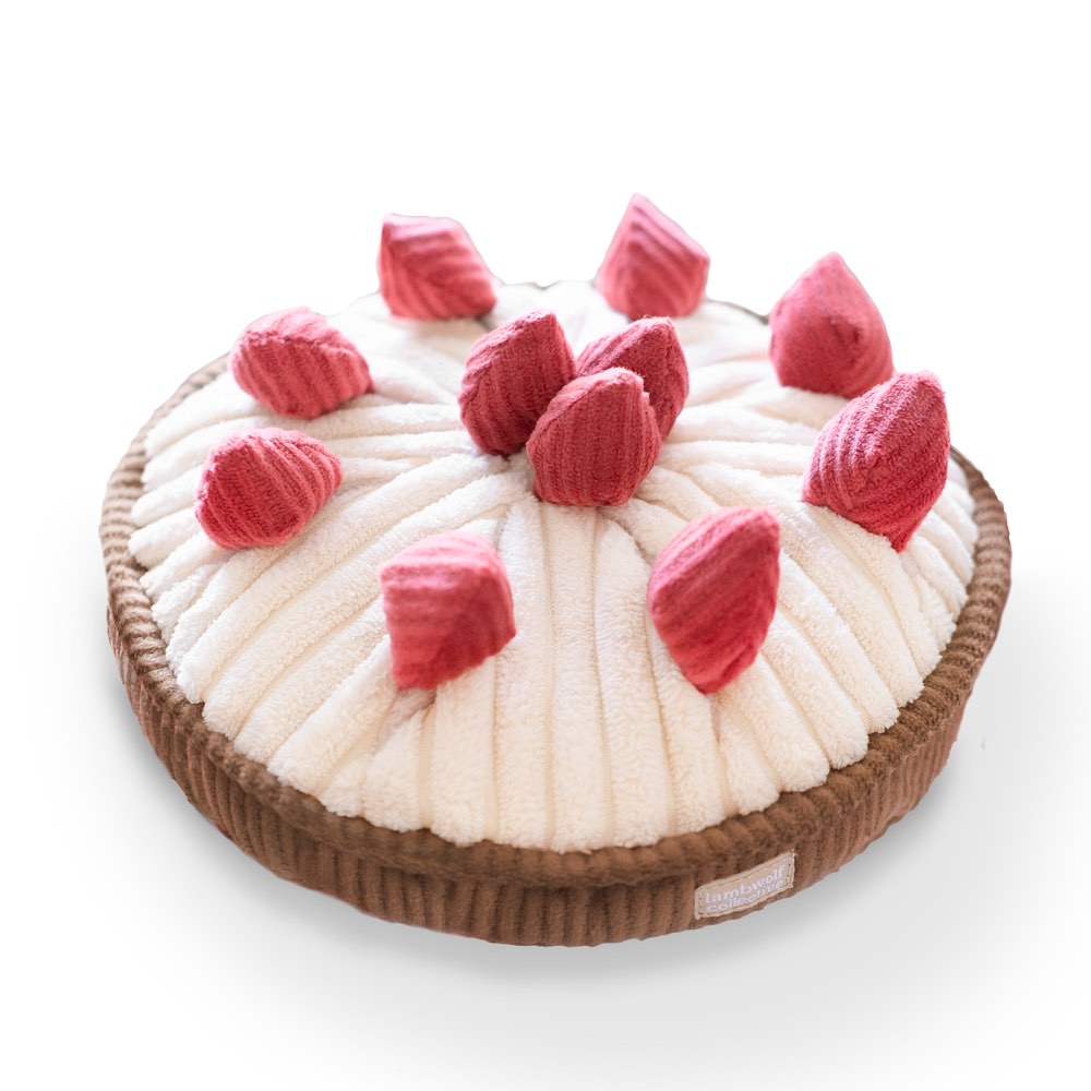 A flat, round enrishment dog toy resembling a pie with pink berry-like toppings and a brown crust.