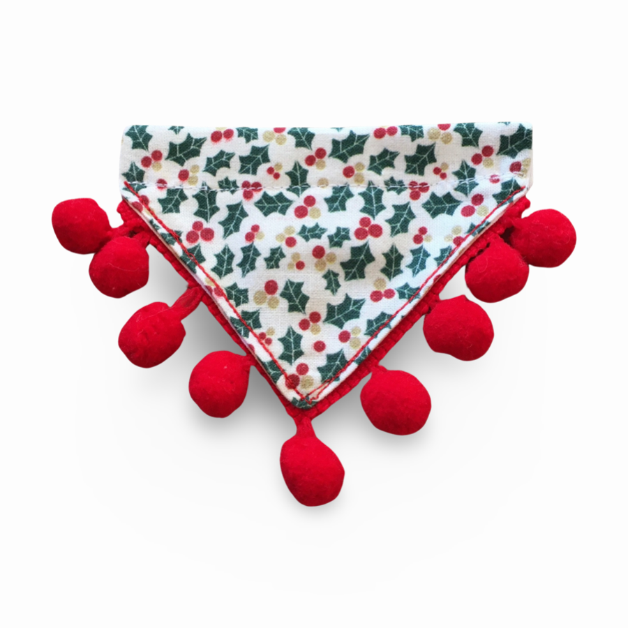 An extra small white dog bandana with a holly and berries print, trimmed with red pompoms.