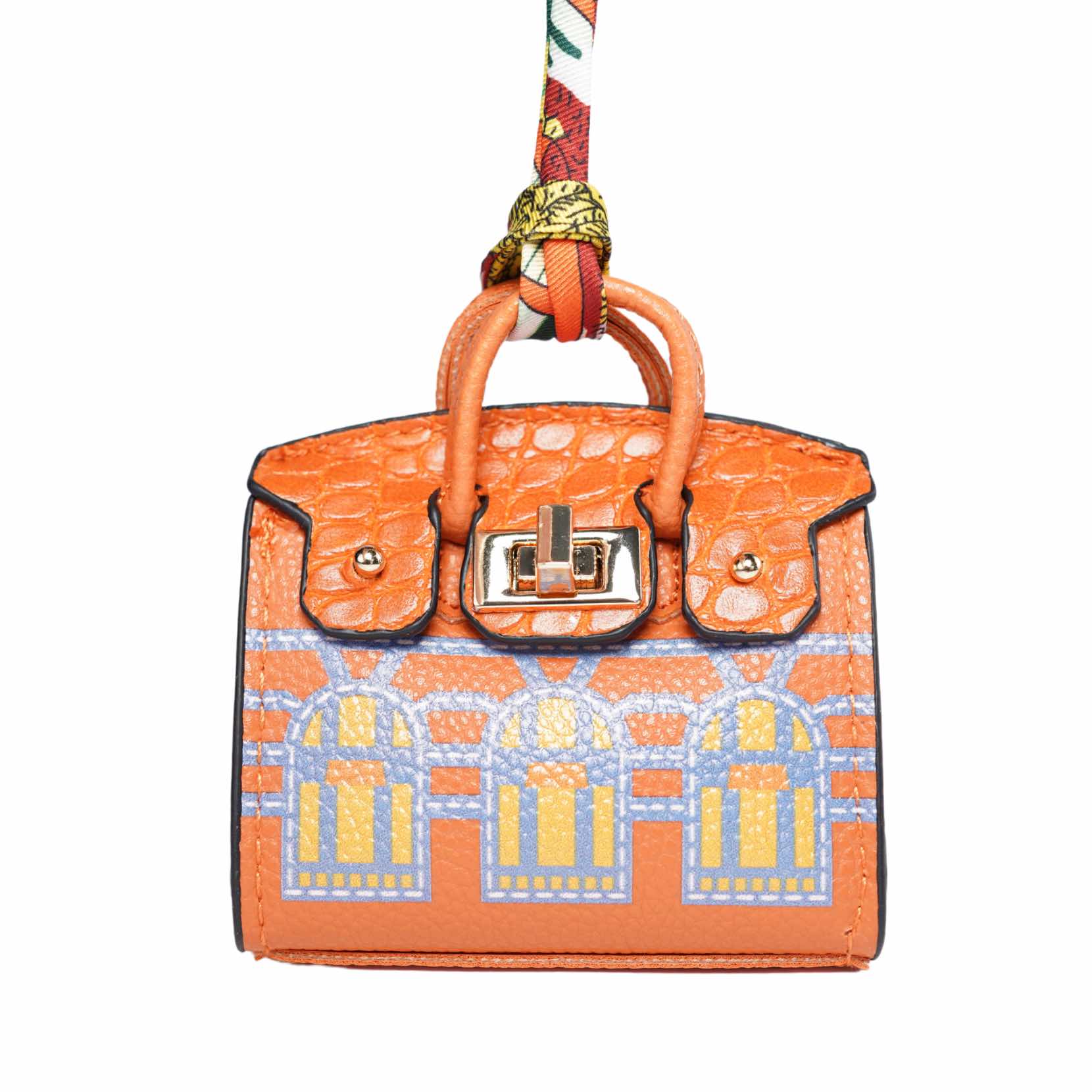 Orange handbag-style dog waste bag holder with gold hardware on a white background.