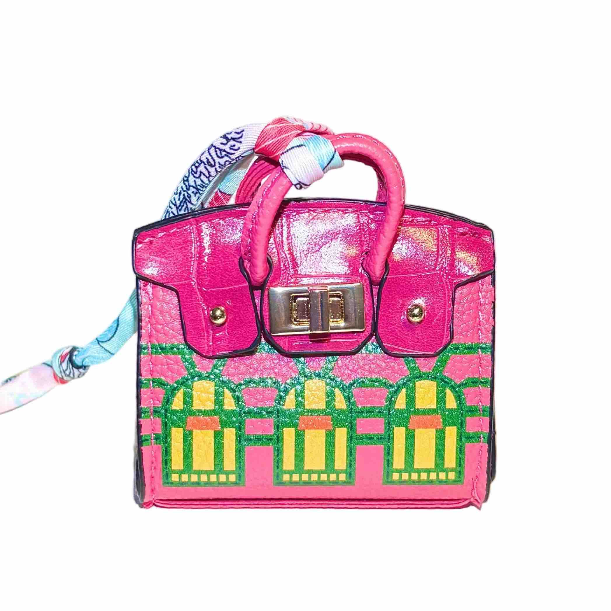 Rose red handbag-style dog waste bag dispenser with gold hardware on a white background.