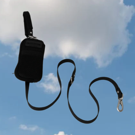 A black walk bag with dog leash on a sky background.