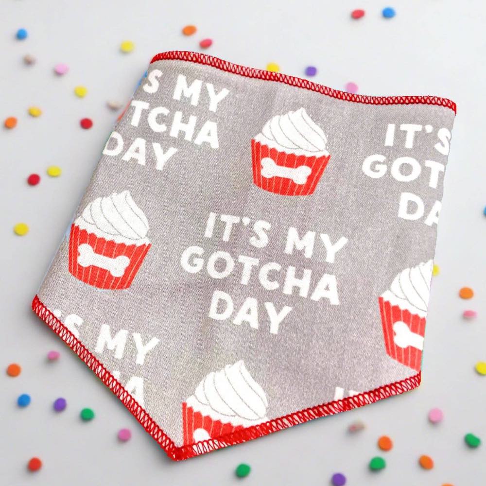 Dog bandana with 'It's My Gotcha Day' text and cupcake design on a light background with colorful confetti.