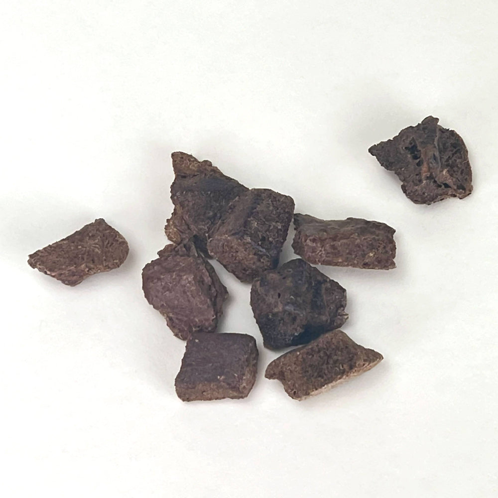 Liver dog treat chunks on a white background.
