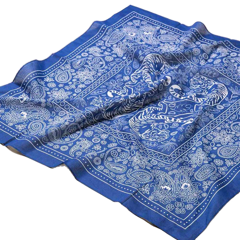 Blue dog bandana with white patterns on a beige background.