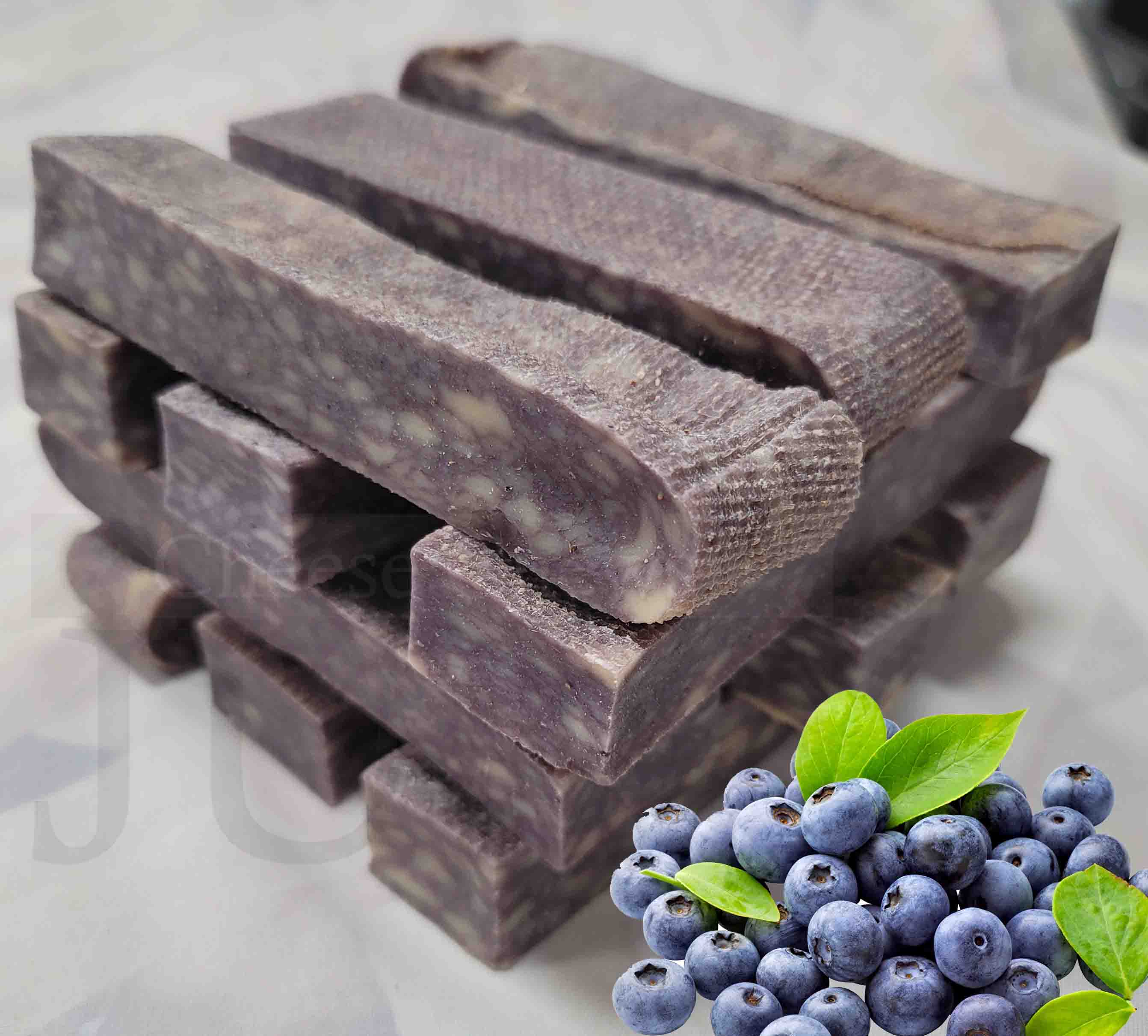 Stack of blueberry Himalayan-style cheese chews with blueberries on a white background.