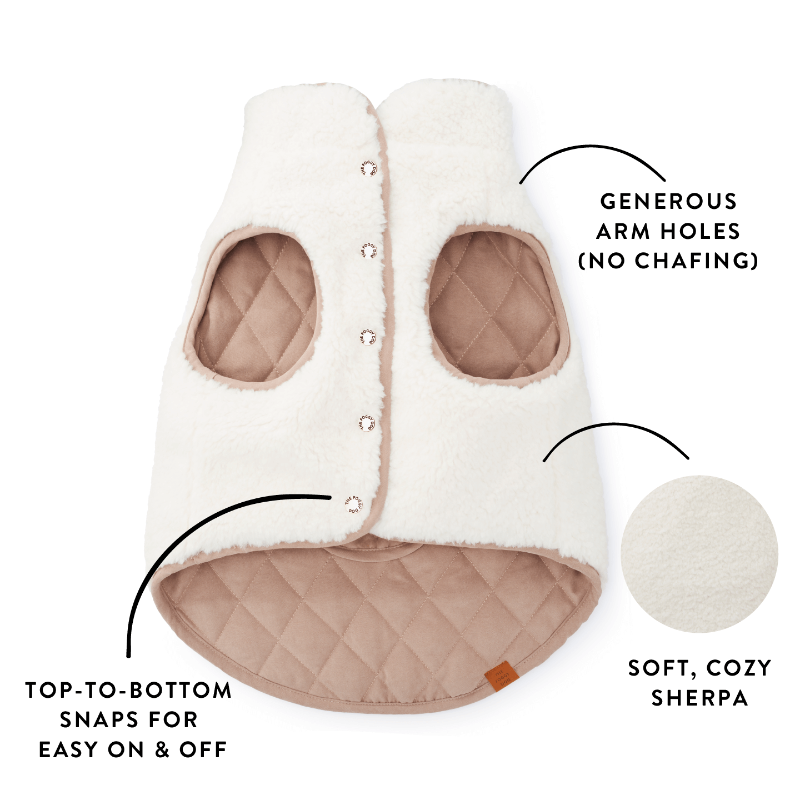 White and beige dog jacket with arm holes, top-to-bottom snap, and soft Sherpa texture on a white background.