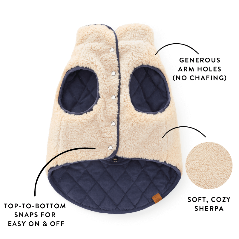 Beige and navy pet coat with arm holes and text highlighting features on a white background